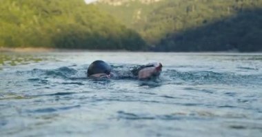 Triatlon sporcusu yüzme antrenmanı Triatlon yarışmasına hazırlanıyor. Açık Su Altında Triatlon Yarışması için Profesyonel Yüzme Eğitimi. Yüksek kaliteli görüntüler. Yavaş çekim