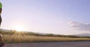 Triatlon - Triatlon erkek triatloncu Triatlon takım elbise ile koşuyor Demir Adam yarışı için. Erkek koşucu sabahları koşuyor. Yavaş çekim takip çekimi. Yüksek kalite 4k görüntü