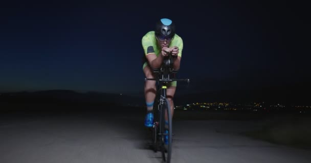 铁人三项全能运动员骑职业自行车的夜间自行车训练 晚上在弯曲的乡间路上进行健康的剧烈运动 慢动作跟踪镜头 — 图库视频影像