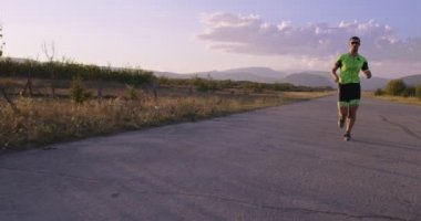 Triatlon - Triatlon erkek triatloncu Triatlon takım elbise ile koşuyor Demir Adam yarışı için. Erkek koşucu sabahları koşuyor. Yavaş çekim takip çekimi. Yüksek kalite 4k görüntü