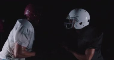 Amerikan futbolcunun rakibini alt edişinin yan görüntüsü. Yüksek kaliteli görüntüler