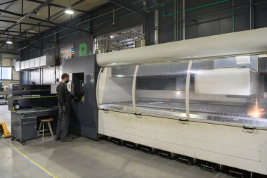 Akıllı bir fabrika işçisi ya da mühendisi salgın yüzünden maske takar ve bir üretim atölyesinde makine yapar. Endüstri ve mühendislik kavramı. Yüksek kalite fotoğraf