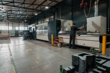 Akıllı bir fabrika işçisi ya da mühendisi salgın yüzünden maske takar ve bir üretim atölyesinde makine yapar. Endüstri ve mühendislik kavramı. Yüksek kalite fotoğraf