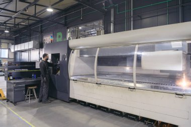 Salgın yüzünden maske takan ve üretim atölyesinde makine yapan zeki bir fabrika işçisi ya da mühendis. Endüstri ve mühendislik kavramı. Yüksek kalite fotoğraf