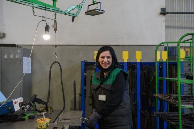 Üniformalı bir kadının portresi bir metal parçası taşıyor ve prodüksiyonun son bölümü için hazırlıyor. Yüksek kalite fotoğraf