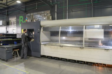 Akıllı bir fabrika işçisi ya da mühendisi salgın yüzünden maske takar ve bir üretim atölyesinde makine yapar. Endüstri ve mühendislik kavramı. Yüksek kalite fotoğraf