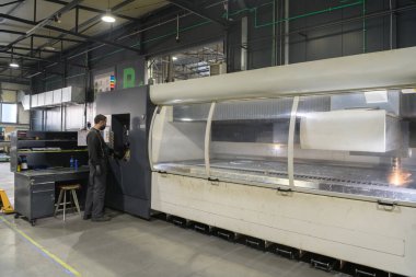 Akıllı bir fabrika işçisi ya da mühendisi salgın yüzünden maske takar ve bir üretim atölyesinde makine yapar. Endüstri ve mühendislik kavramı. Yüksek kalite fotoğraf