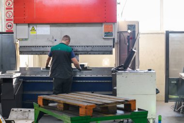 Akıllı bir fabrika işçisi ya da mühendisi salgın yüzünden maske takar ve bir üretim atölyesinde makine yapar. Endüstri ve mühendislik kavramı. Yüksek kalite fotoğraf