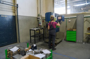 Modern metal endüstrisinde çalışırken ve matkap kullanırken koronavirüs salgınından dolayı maske takan bir kadın. Yüksek kalite fotoğraf