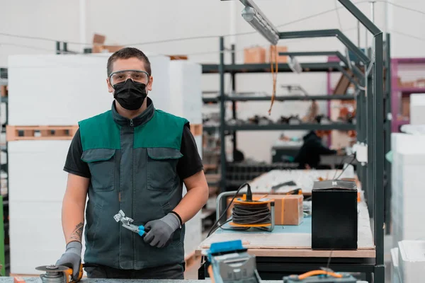 重工业工程工厂内部工业工人使用角磨床和切割金属管他戴着面具在他的脸上因为科罗纳威斯大流行病 高质量的照片 — 图库照片