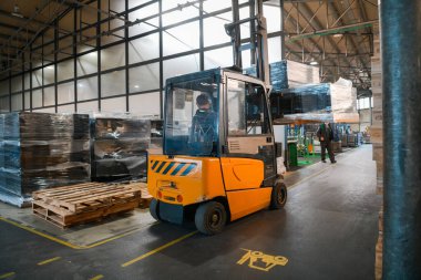 Depo tersanesinde forklift yükleyicisi. Dağıtım ürünleri. Teslimat. Lojistik. Ulaşım. İş geçmişi. Yüksek kalite fotoğraf