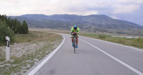 三项全能运动的运动员骑着专业的赛车场 在弯曲的乡间路上锻炼 慢动作跟踪镜头 — 图库视频影像