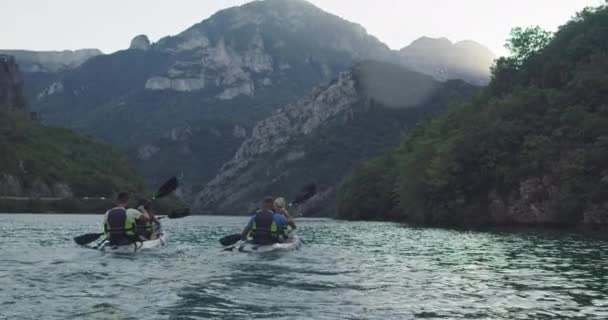 皮划艇慢动作 Kayaker的女人和男人和朋友一起在美丽的风景中划船 皮划艇手在湖边的皮划艇上做运动 夏季水上运动 高质量的4K镜头 — 图库视频影像