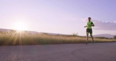 Triatlon - Triatlon erkek triatloncu Triatlon takım elbise ile koşuyor Demir Adam yarışı için. Erkek koşucu sabahları koşuyor. Yavaş çekim takip çekimi. Yüksek kalite 4k görüntü