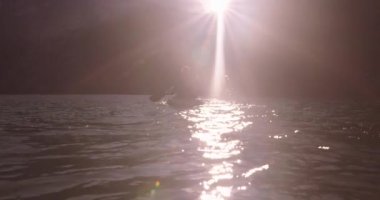 Kano yapmak için güzel bir gün. Güzel genç bir çift gölde kayak yapıyor ve gülümsüyor. 