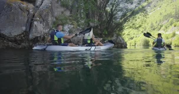 Kajak roeien slow motion. Kayaker vrouw en man kajakken in een prachtig landschap. Kayakers beoefenen sport in een kajak aan het meer met vrienden. Watersport in de zomer. — Stockvideo