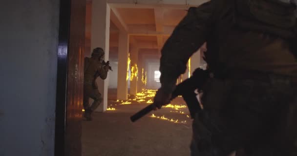 Une équipe masquée de soldats de la guerre moderne armés se déplace en formation tactique dans un champ de bataille urbain obscur à l'intérieur.. — Video