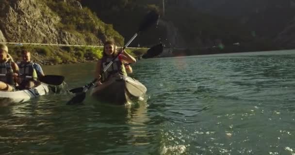 Caiaque remando câmera lenta. Kayaker mulher e homem caiaque em uma bela paisagem. Os kayakers praticam esportes em um caiaque no lago com amigos. Esportes aquáticos durante o verão. — Vídeo de Stock