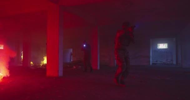 Masked Team of Armed Modern Warfare Soldiers Team Move in Tactical Formation in a Dark Urban Battlefield Indoors.Soldiers Squad with Rifles and Flashlights in action. — стокове відео
