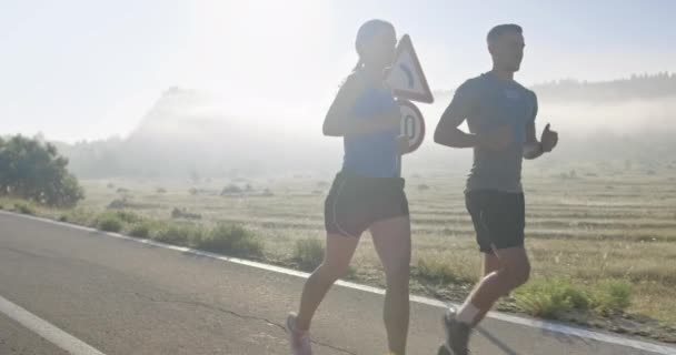 午前中に屋外でスポーティなカップルジョギング 自然の中でトレイルランニングの経験 健康的なライフスタイルのコンセプト 高品質の映像 選択的フォーカス スローモーション撮影 — ストック動画