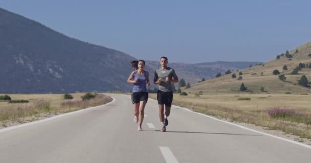 午前中に屋外でスポーティなカップルジョギング 自然の中でトレイルランニングの経験 健康的なライフスタイルのコンセプト 高品質の映像 選択的フォーカス スローモーション撮影 — ストック動画
