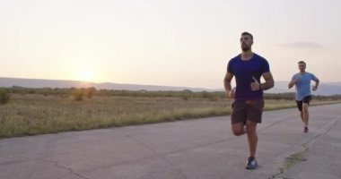 Dayanıklılık içinde yolda koşanlar güzel bir manzarada açık havada koşarlar. Yüksek kaliteli görüntüler