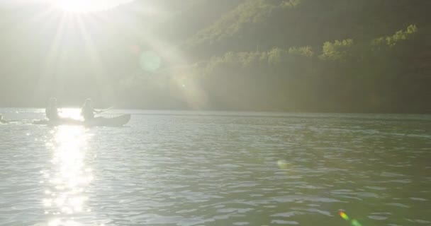Caiaque remando câmera lenta. Kayaker mulher e homem caiaque em uma bela paisagem. Os kayakers praticam esportes em um caiaque no lago com amigos. Esportes aquáticos durante o verão. — Vídeo de Stock