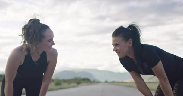 Dua perempuan beristirahat setelah berlari dan merayakan keberhasilan pelatihan dengan tos — Stok Video