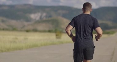 Rear or back view of jogger during intense training in the morning. Runner sprinting during outdoors training for marathon run.