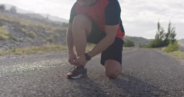 Gros plan. Les mains de l'homme attachent les lacets sur la chaussure de sport. — Video