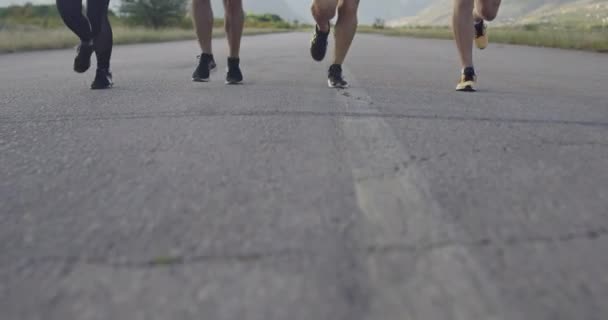 Gruppo multietnico di atleti che corrono insieme su una strada panoramica di campagna. Diversi team di corridori durante l'allenamento mattutino. — Video Stock