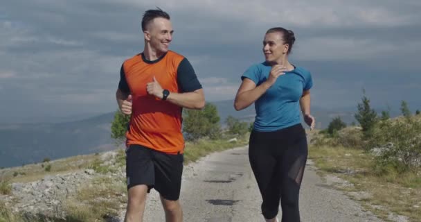 Sledování zpomaleného záběru sportovního páru jogging venku v dopoledních hodinách, stezka běží zkušenosti v přírodě. Zdravý životní styl koncept. — Stock video