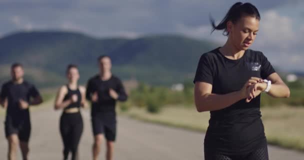 Grupo multiétnico de atletas corriendo juntos en una carretera panorámica. — Vídeos de Stock