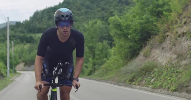 Triatlon sportoló atléta kerékpáros lovaglás profi versenykerékpár. Fekete sportruházat viselése. — Stock videók