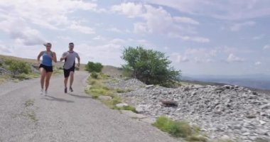 Spor yapan bir çiftin sabah dışarıda koşarkenki yavaş çekim görüntüleri, doğa tecrübeleri. Sağlıklı yaşam tarzı kavramı.