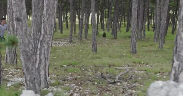 Άνδρας αθλητής τρέχει μέσα στο δάσος. Ένας δραστήριος νεαρός που κάνει έντονη προπόνηση τζόγκινγκ.. — Αρχείο Βίντεο