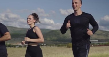 Panoramik bir kırsal yolda birlikte koşan çok ırklı bir grup sporcu. Sabah antrenmanına çıkan çeşitli koşucular.. 