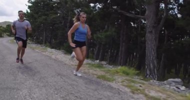 Spor yapan bir çiftin sabah dışarıda koşarkenki yavaş çekim görüntüleri, doğa tecrübeleri. Sağlıklı yaşam tarzı kavramı.