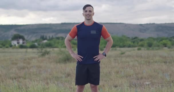 Retrato del tipo determinado de pie en la carretera en ropa deportiva y la preparación para la carrera de la mañana — Vídeo de stock