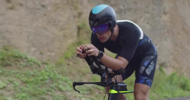 Closeup shot of triathlon sportsman athlete cyclist riding professional racing bicycle. — Video