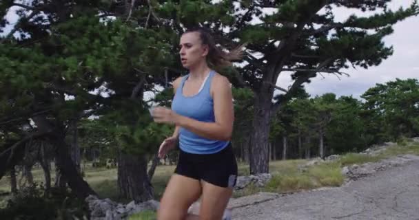 Determined sporty woman running trail alone on the road and preparing for a marathon. Sport and freedom concept. — Stock Video