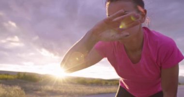 Formda ve aktif genç bir kadın koşuya ara veriyor. Yorgun koşucu geceleri şehir sokağında soluklanıyor. 4k