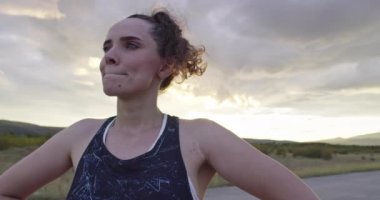 Formda ve aktif genç bir kadın koşuya ara veriyor. Yorgun koşucu geceleri şehir sokağında soluklanıyor. 4k