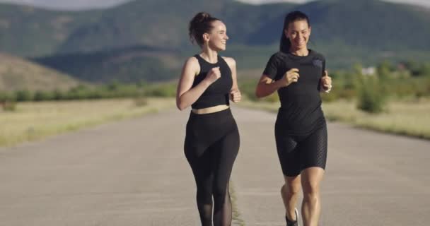 Two women in sportswear running on a sunny day and preparing for a marathon — Video Stock