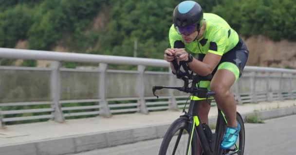 Closeup shot of triathlon sportsman athlete cyclist riding professional racing bicycle. — стоковое видео