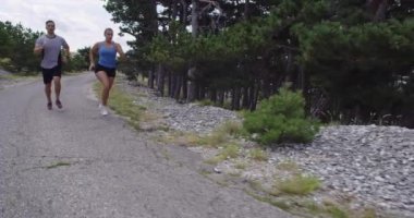 Spor yapan bir çiftin sabah dışarıda koşarkenki yavaş çekim görüntüleri, doğa tecrübeleri. Sağlıklı yaşam tarzı kavramı.
