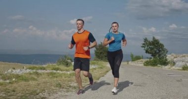 Spor yapan bir çiftin sabah dışarıda koşarkenki yavaş çekim görüntüleri, doğa tecrübeleri. Sağlıklı yaşam tarzı kavramı.