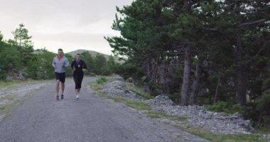 Spor yapan bir çiftin sabah dışarıda koşarkenki yavaş çekim görüntüleri, doğa tecrübeleri. Sağlıklı yaşam tarzı kavramı.