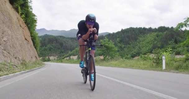 Triathlon sportsman athlete cyclist riding professional racing bicycle. Wearing black sportswear. — стоковое видео