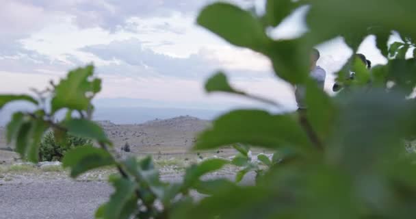 Couple of determined athletes stretching together, warming up and preparing for running training on a panoramic road. — Stock videók